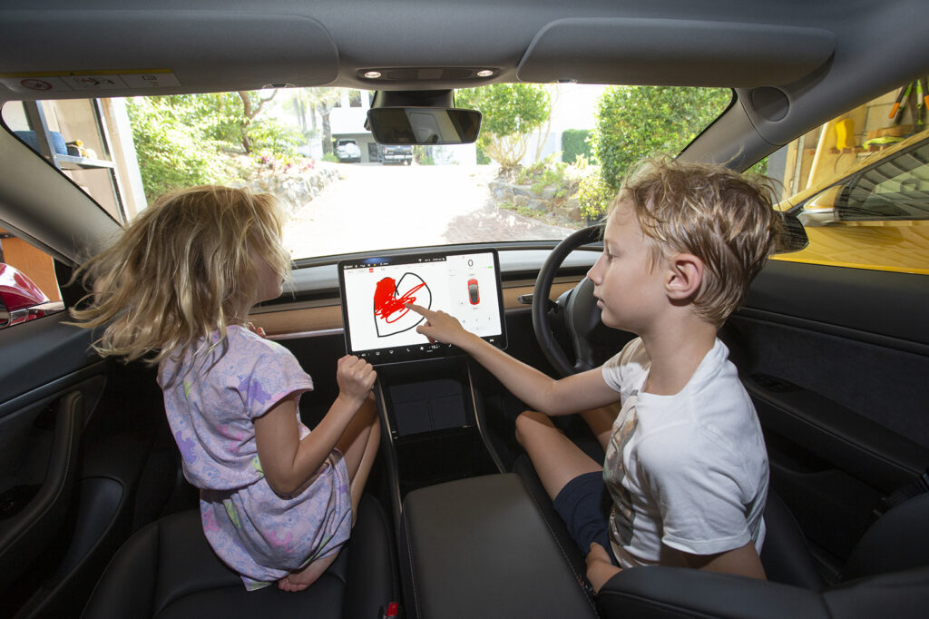 Kids using the sketchpad in the 2020 Tesla Model 3 Performance