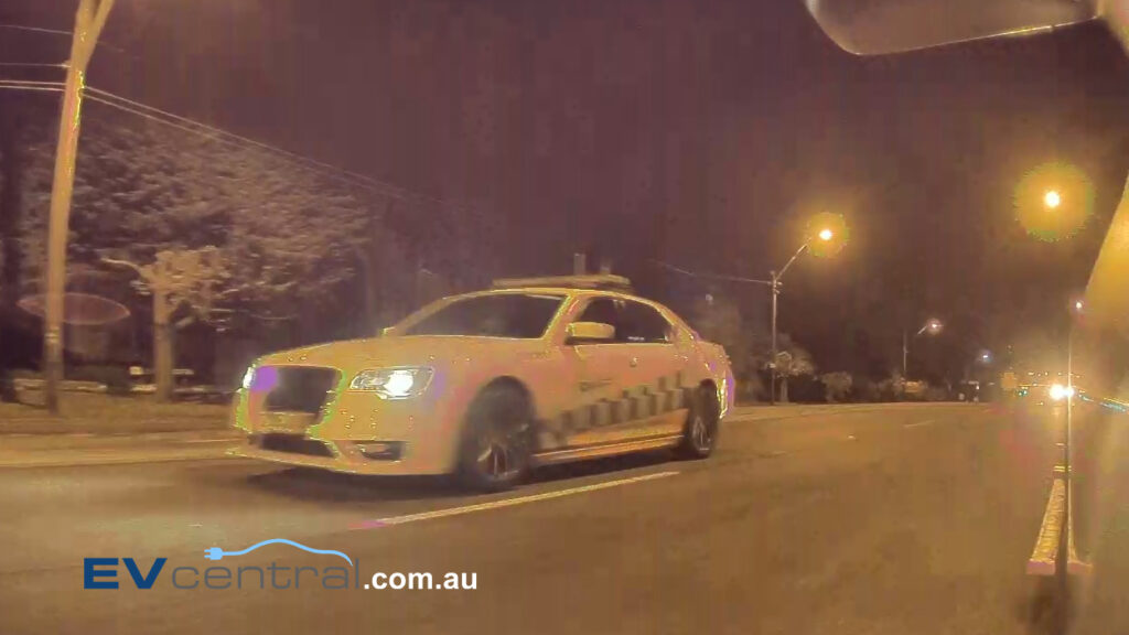 A screen shot from the camera of a Tesla Model 3 showing a Chrysler 300 SRT Core in pursuit of two vehicles in NSW