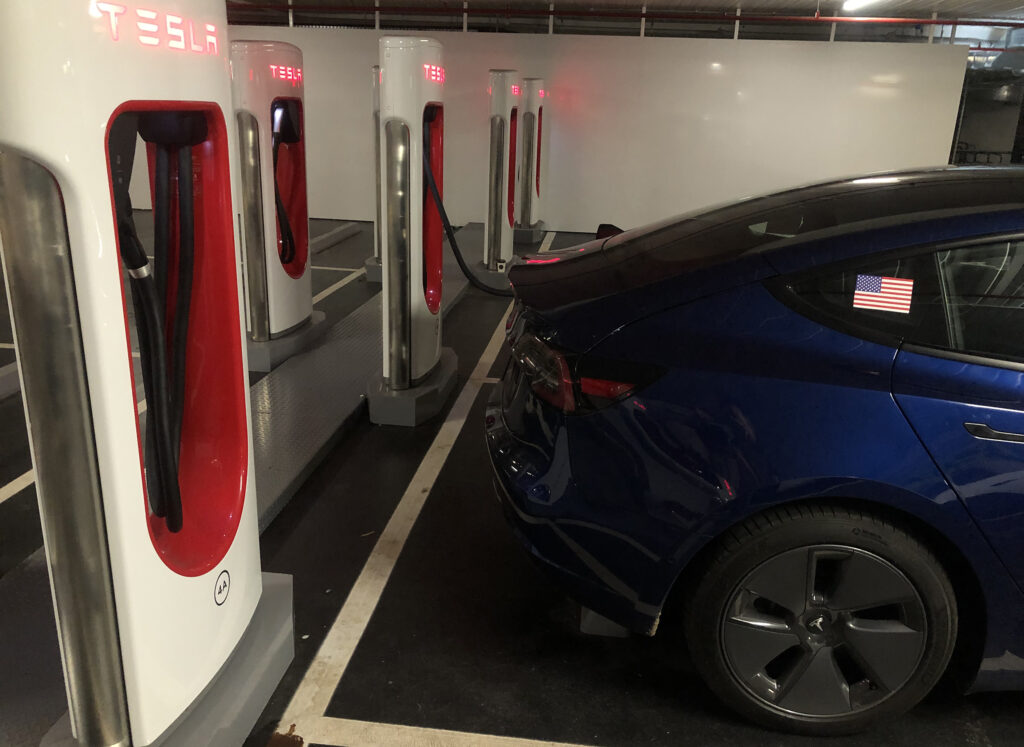 Tesla Model 3 charging at a Tesla Supercharger station