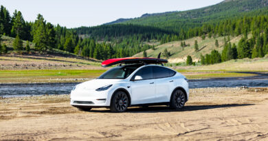 Tesla Model Y with a SUP on its roof racks