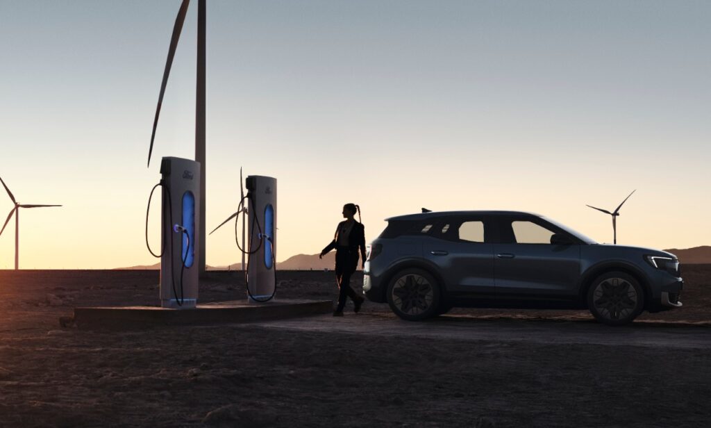 New Ford Explorer EV being charged at a wind farm