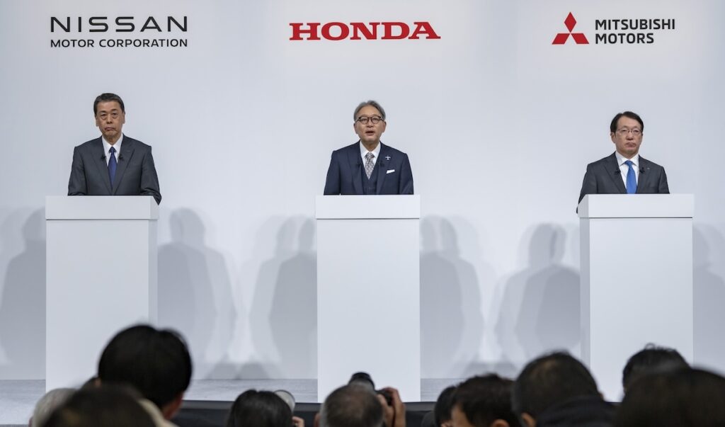 The chiefs of Nissan, Honda and Mitsubishi announce their merger plan to the press.